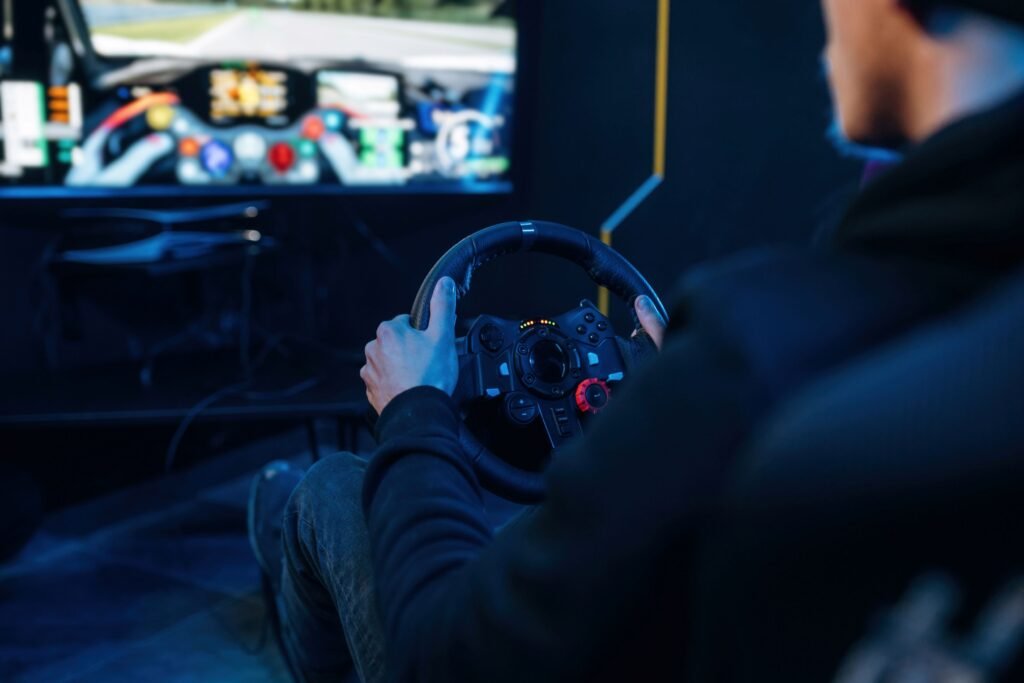 Man using a racing simulator steering wheel while driving on a virtual racetrack screen