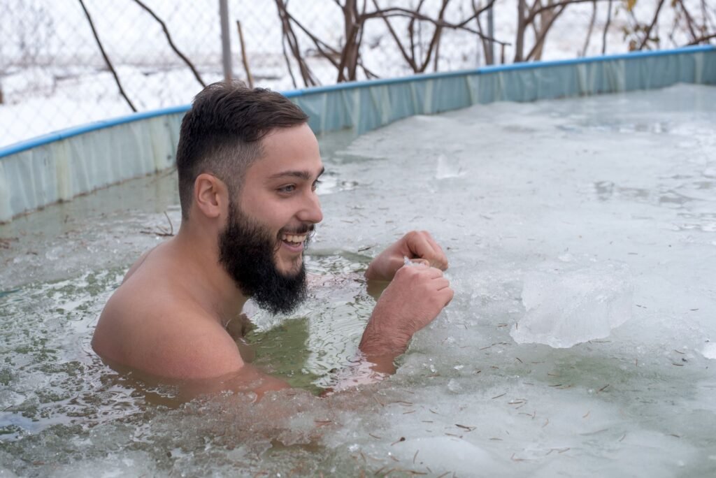 Man immersing in an outdoor ice bath for cold therapy and muscle recovery